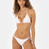 Woman wearing a white bikini on a white background looking at the camera