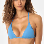 Woman wearing a blue bikini top against a white background