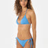Woman wearing a blue bikini against a white background