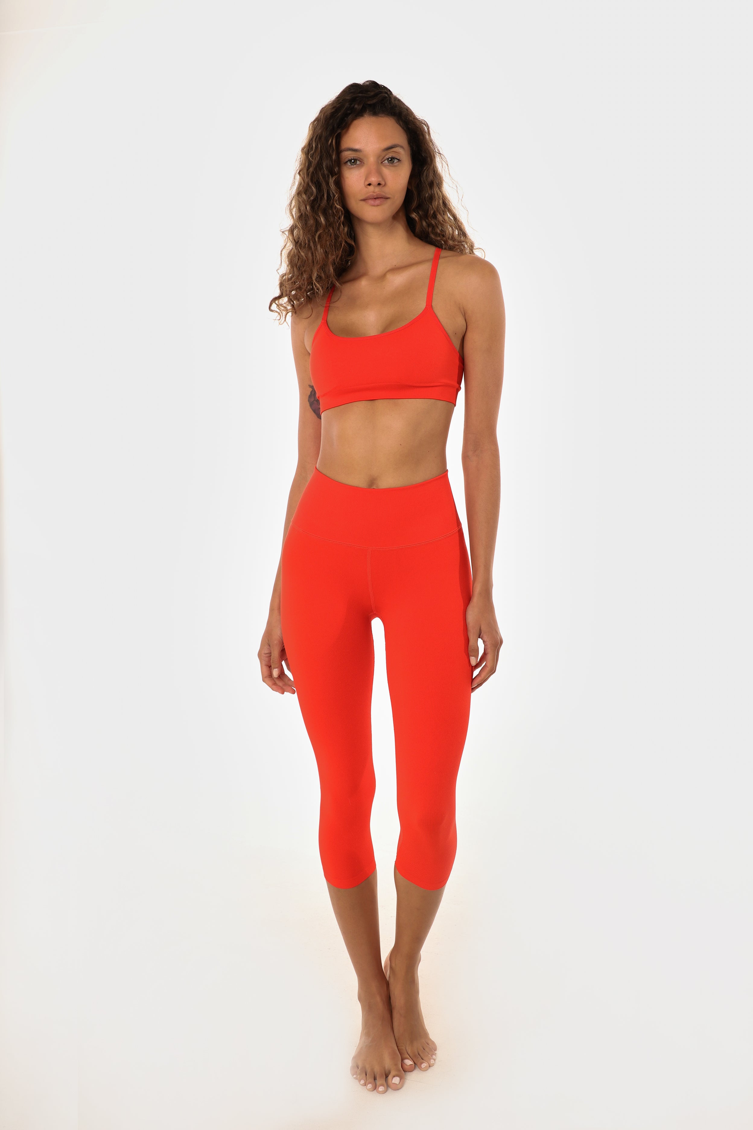 Woman in poppy athletic set looking at the camera.