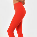 Close up view of poppy colored women's leggings. 