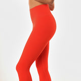 Close up view of poppy colored women's leggings. 