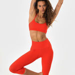 Woman in poppy athletic set posing.